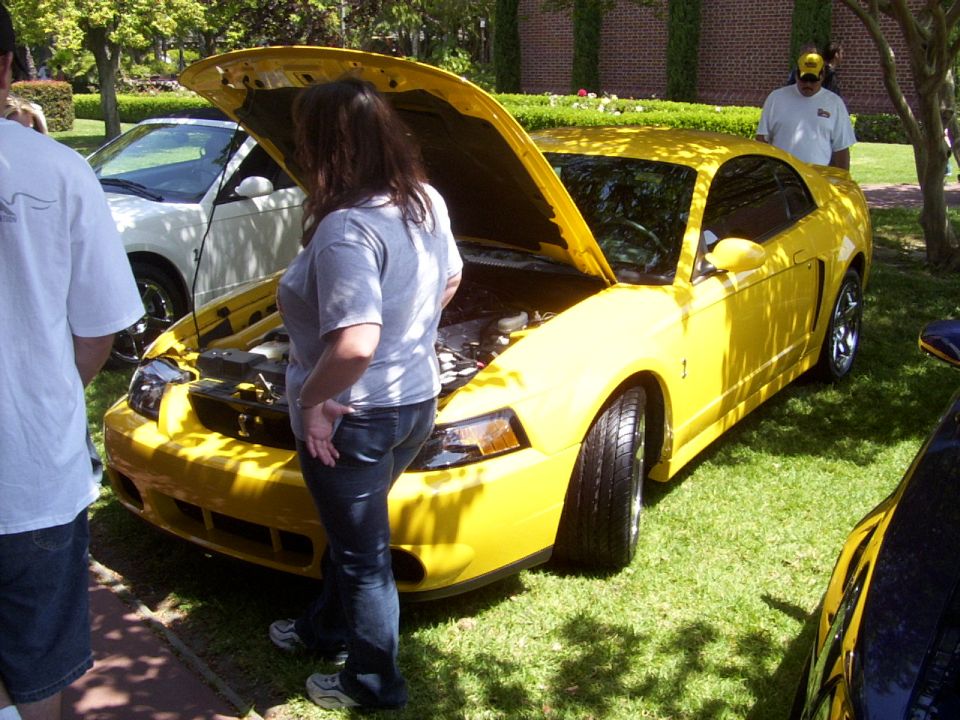 Yellow Ford Mustang with hood open, viewed from the front-right