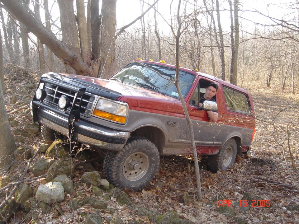 Red and grey SUV on rocky trail, driver looking out window. Date stamp reads 4/16/2005