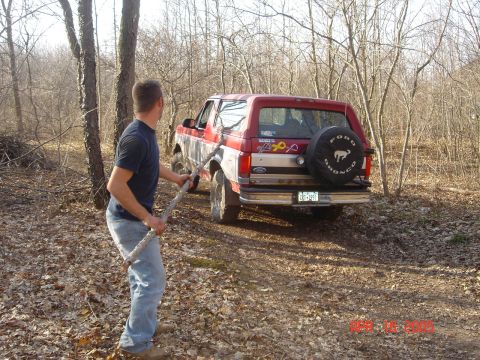 1995 Ford Bronco - 1995 Ford Bronco with spare tire on rear door, seen off-road in wooded area.