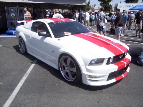 2002 Ford Mustang - White 2005 Ford Mustang GT with red racing stripes and aftermarket body modifications.