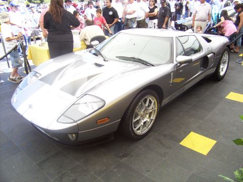 2002 Ford Mustang - Silver Ford GT with racing stripes on hood and roof, seen at an outdoor event.