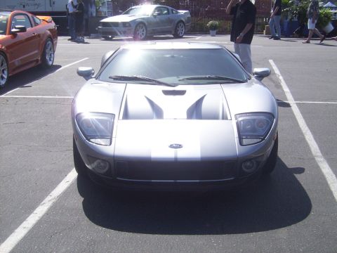 2002 Ford Mustang - A silver Ford GT is parked in a lot, showing its distinctive front end and racing stripes.