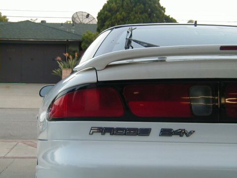 1993 Ford Probe - The rear of a white Ford Probe is visible, its taillights and a spoiler.