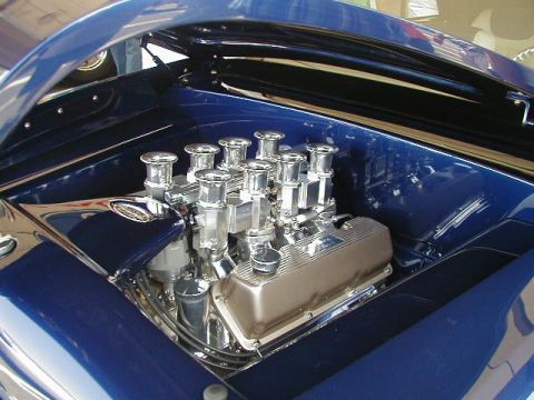1993 Ford Probe - The engine bay of a custom blue vehicle is shown with a V8 engine and chrome details.