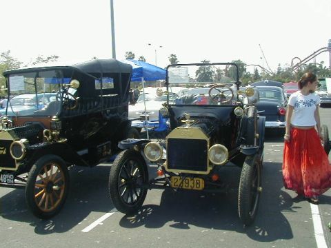 1993 Ford Probe - Two vintage Ford Model T cars are displayed outdoors, with a woman standing near one of them.