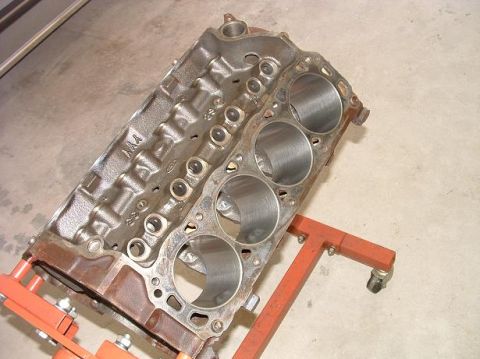 1985 Ford LTD Crown Victoria - Engine block on an orange stand, showing cylinder bores and cast markings.