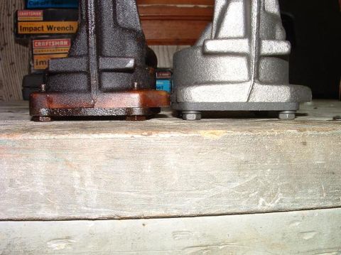 1985 Ford LTD Crown Victoria - Comparison of a used engine part with a newly cleaned or replaced one, set against a backdrop of tool boxes.