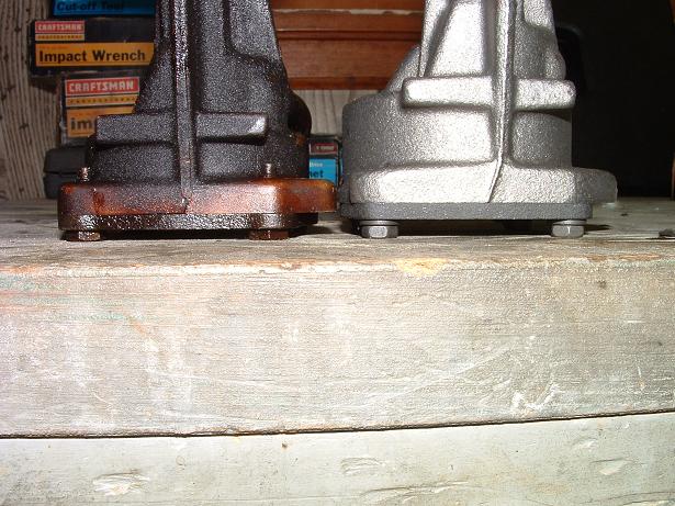 Two engine parts, one rusted and one clean, side-by-side on a workbench