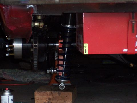1971 Ford Mustang - Close-up view of a car's rear suspension and fuel tank assembly.