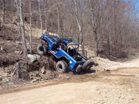 1974 Ford Bronco - This custom buggy is navigating a challenging off-road trail with steep inclines and loose terrain.