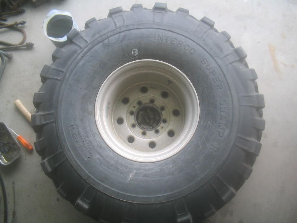 Large Interco Super Swamper tire on a silver rim with multiple lug holes