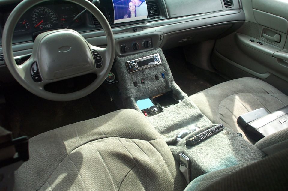 Crown Victoria interior with custom carpeted center console, aftermarket stereo, and gray cloth seats