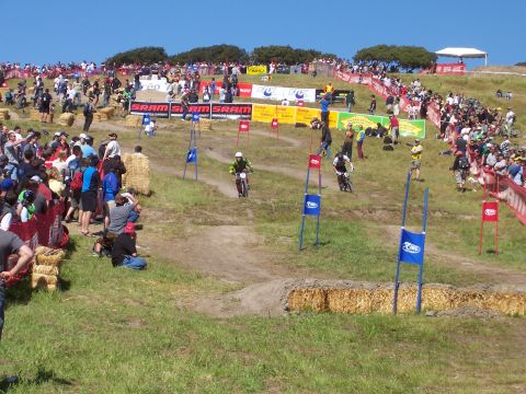 1998 Ford Ranger - A downhill mountain bike race is underway with spectators lining the course and hay bales marking the track.