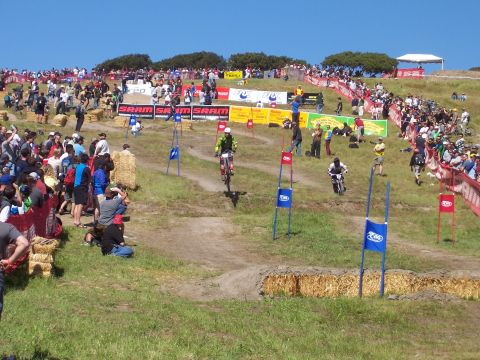 1998 Ford Ranger - A downhill mountain bike race is underway with riders navigating a challenging course as crowds watch from the sidelines.