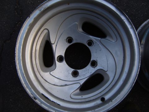 1993 Ford Bronco - Close-up of a single silver alloy wheel, showing its distinctive three-spoke pattern and five lug nut openings.