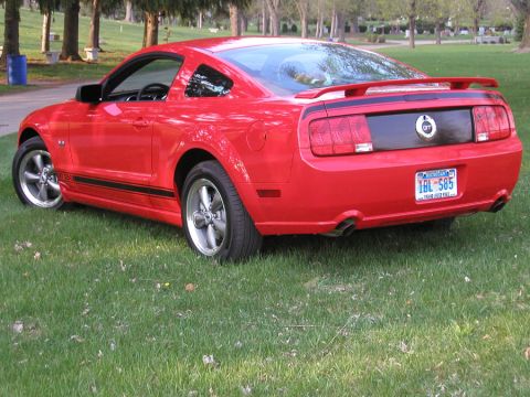 2005 Ford Mustang - This red 2005 Ford Mustang GT coupe is viewed from the rear, showing its spoiler and racing stripes.