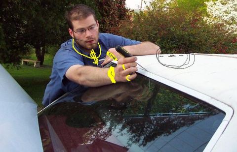 1985 Ford Crown Victoria LTD - Man with dollar sign necklace and watch works on the roof of a white car.