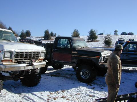 1979 Ford F-150 - Two pickup trucks are parked in a snowy field under a clear blue sky.