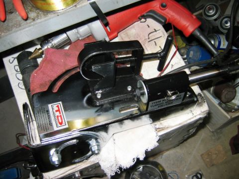 1985 Ford Bronco - A black tubing notcher tool is shown on a workbench with other tools and supplies.