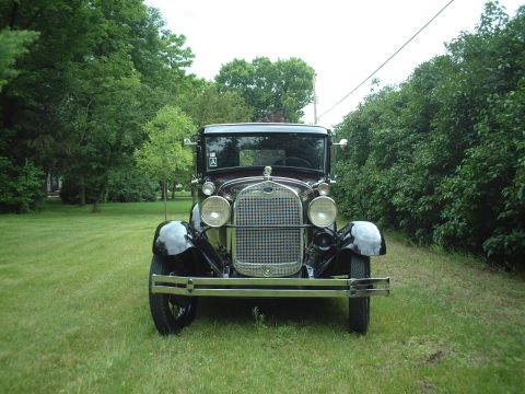 1929 Ford Model A - A classic 1929 Ford Model A sits on a grassy lawn surrounded by trees.