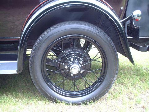 1929 Ford Model A - Close-up view of the black wire wheel and fender of a 1929 Ford Model A, highlighting its vintage design.