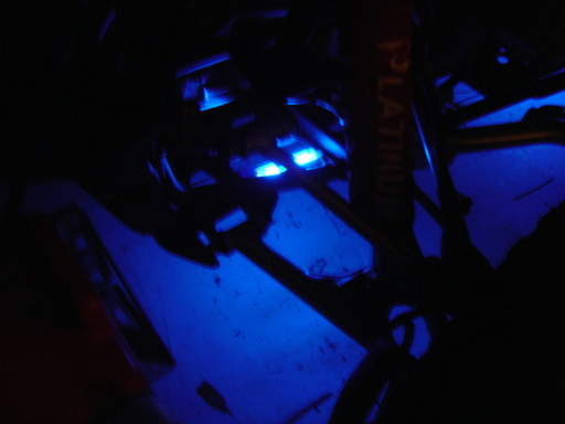 Dark photo of ATV parts lit by blue LED accent lights at night