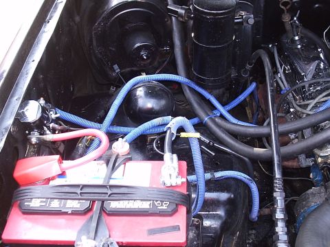 1985 Ford Bronco - Close-up view of an engine bay, showing the battery and various hoses and wiring.