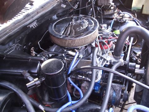 1985 Ford Bronco - Close-up view of a vehicle's engine bay, showing various components and wiring.