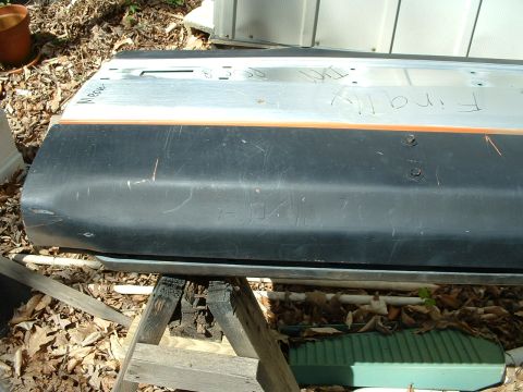 1985 Ford Bronco - Door panel with handwritten markings, including '85 86 FINALLY', is shown resting on sawhorses.