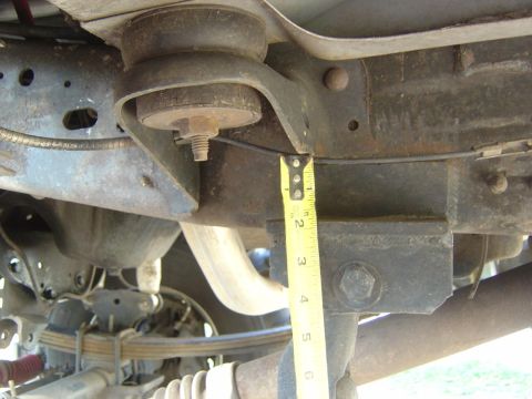 1993 Ford Bronco - A tape measure is used to measure the clearance of suspension components on a vehicle's undercarriage.
