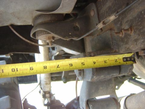 1993 Ford Bronco - A measuring tape is used to measure a suspension component on a vehicle, indicating approximately 6 inches.