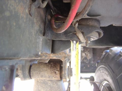 1993 Ford Bronco - A tape measure is used to gauge the distance of a suspension component on a vehicle.