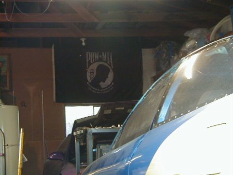 1993 Ford Probe - Interior view of a blue and white vehicle, with a POW-MIA flag hanging on the wall behind it.