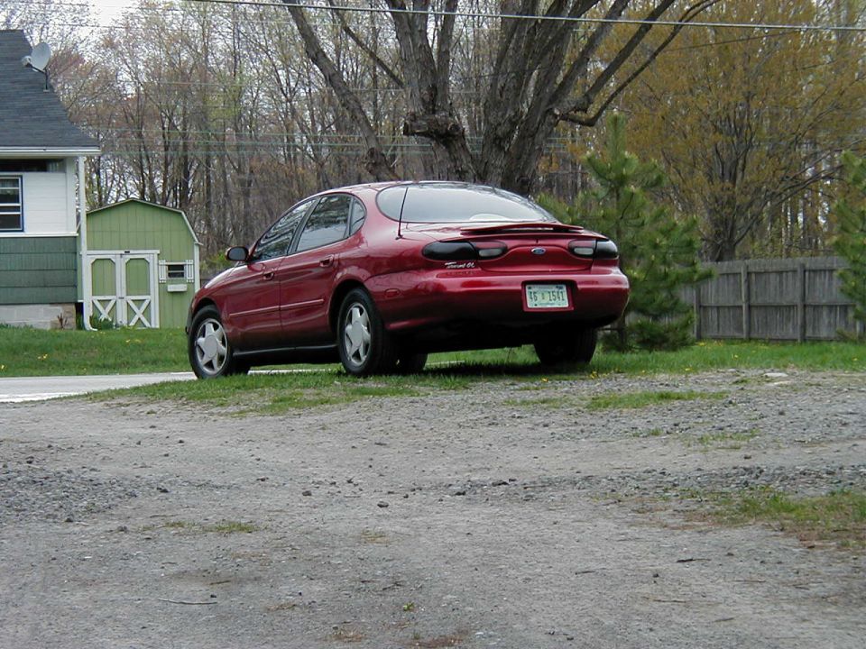 Red 1997 Ford Taurus sedan, rear view, with a spoiler and license plate TF Y541