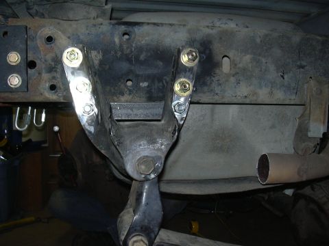 1991 Ford Bronco - Underside view of a fabricated steel crossmember or bracket bolted to the frame with new zinc-plated bolts, likely part of a suspension or…