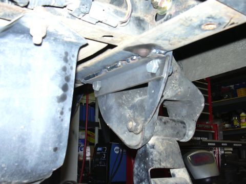 1991 Ford Bronco - Underside view of a vehicle showing a welded steel bracket or mount fastened to a frame rail with hex bolts, appearing freshly fabricated a…
