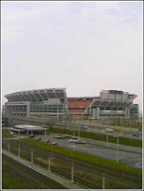 1993 Ford Bronco - A wide view of a large stadium complex with traffic on the highway below and train tracks in the foreground.