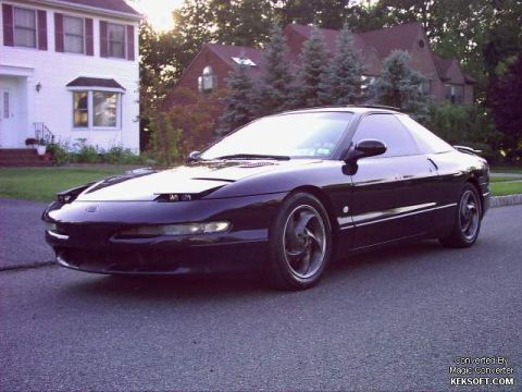1997 Ford Probe - A 1997 Ford Probe is parked on a street in front of a residential house.