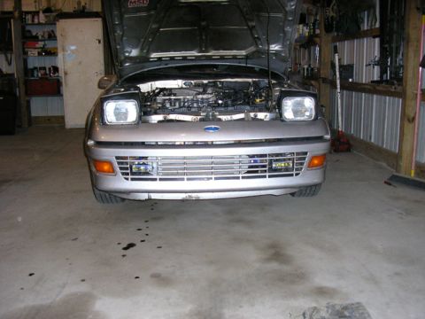 1990 Ford Probe - A silver 1990 Ford Probe is parked in a garage with its hood up, revealing the engine bay.