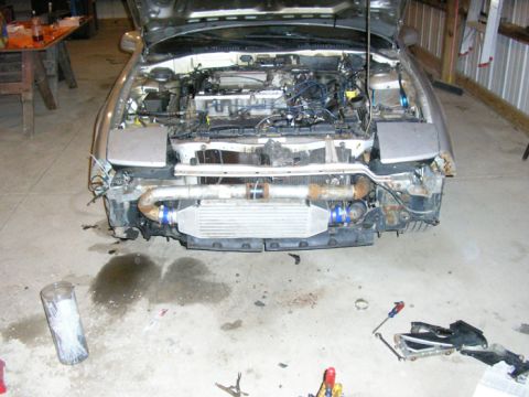 1990 Ford Probe - The front of a car is shown with the hood open, revealing the engine and an aftermarket intercooler installed.