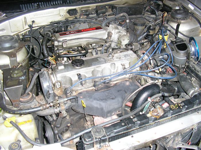 Engine bay with 2.5L TURBO engine cover and various hoses and wires