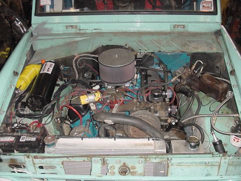 1969 Ford Bronco - The engine bay of a 1969 Ford Bronco shows an aftermarket air filter and yellow air intake hose.