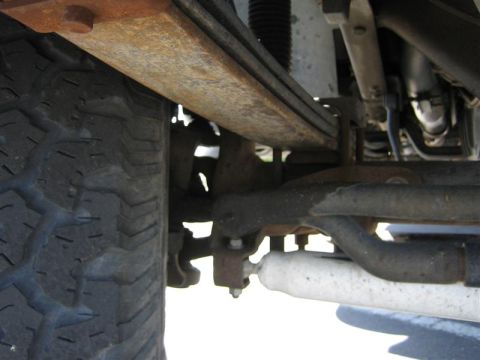 1999 Ford F-250 - Close-up of the rear suspension components on a 1999 Ford F-250, showing the leaf spring and tire.