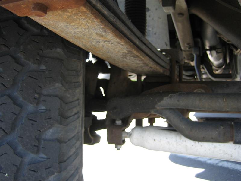 Underbody view of front leaf spring, tie rod end and white steering stabilizer