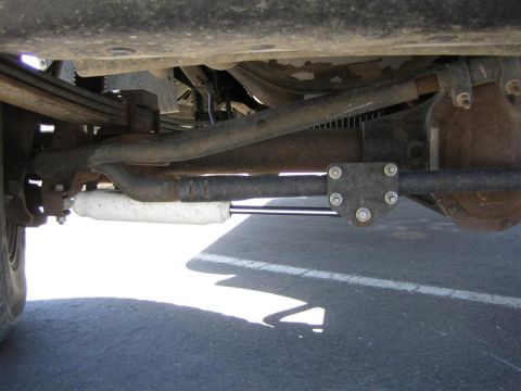 1999 Ford F-250 - Close-up view of the steering linkage and shock absorber assembly on a heavy-duty truck.