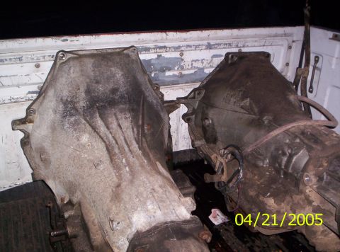 1985 Ford Bronco - Two transmission assemblies are loaded into the bed of a pickup truck.