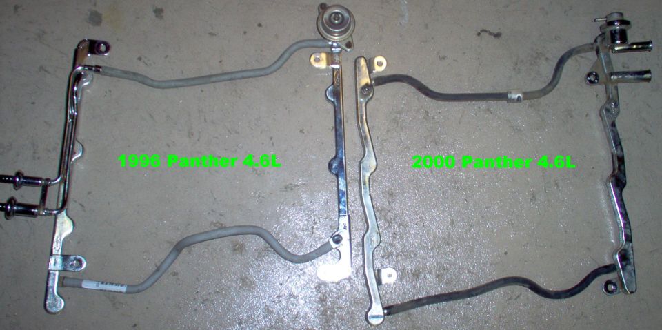 Two fuel rail or steering linkage assemblies side by side on concrete labeled by year