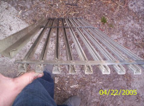 1985 Ford Bronco - A metal car grille with vertical bars and a separate channel piece is shown on the ground.