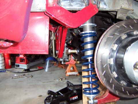 1971 Ford Mustang - Close-up of a car's suspension and brake system during repair.