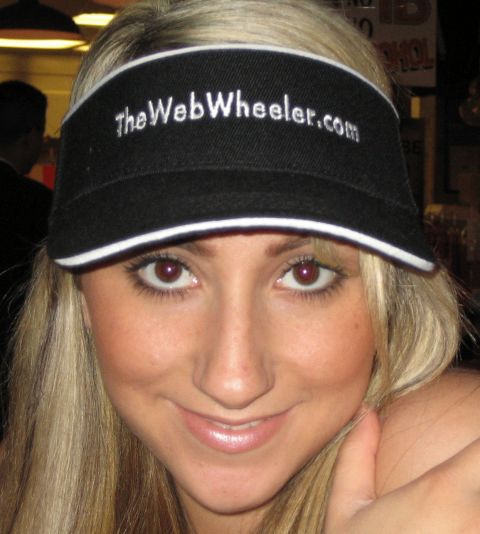 1990 Ford Bronco - smiling blonde woman wears a black visor embroidered with TheWebWheeler.com.